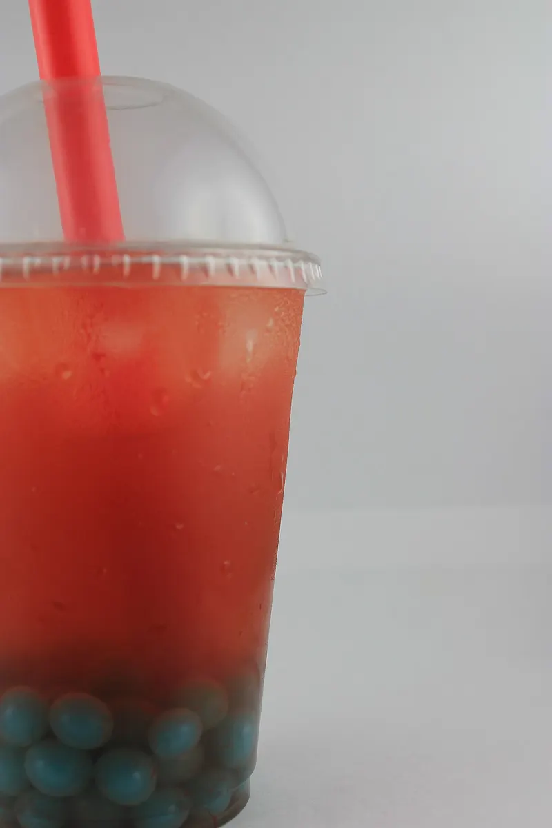 Vaso de té de fruta roja con perlas de tapioca y pajita