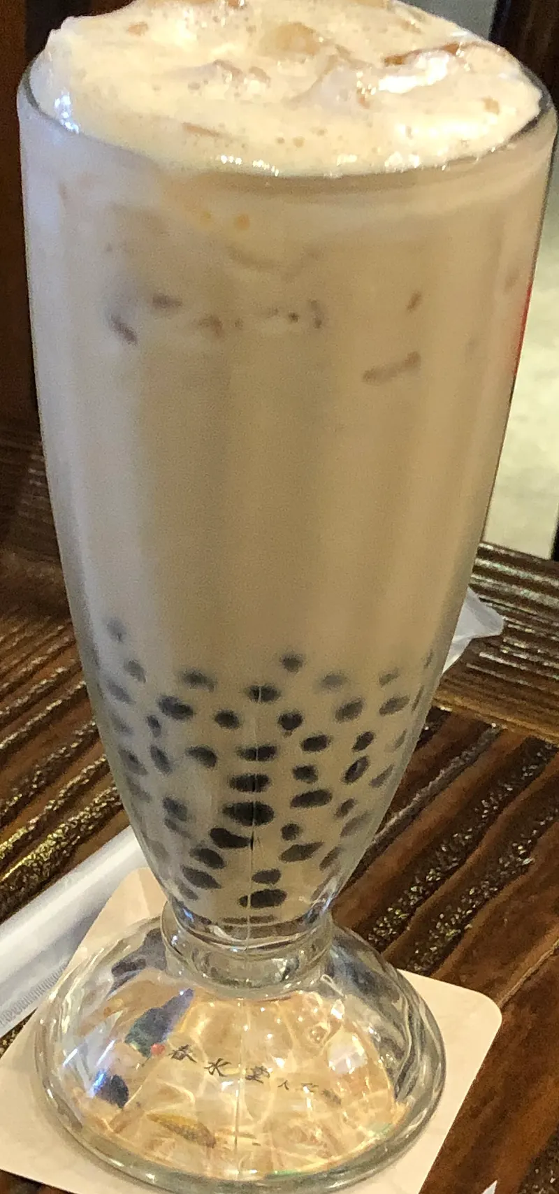 Té con leche y perlas de tapioca en un vaso alto