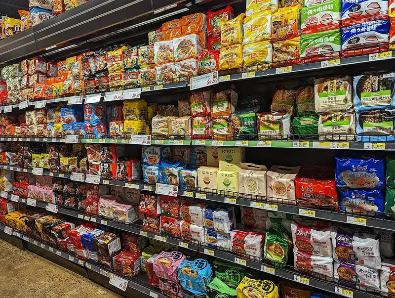 Estanterías llenas de paquetes de ramen instantáneo coreano y japonés