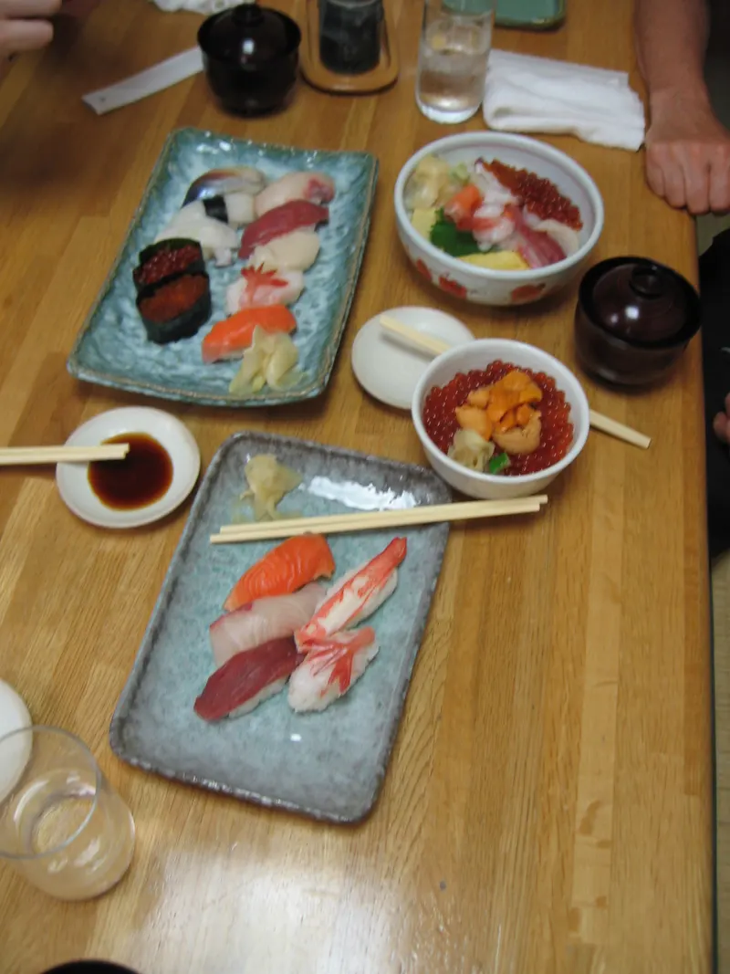 Bandejas de sushi y nigiri variados sobre una mesa de madera
